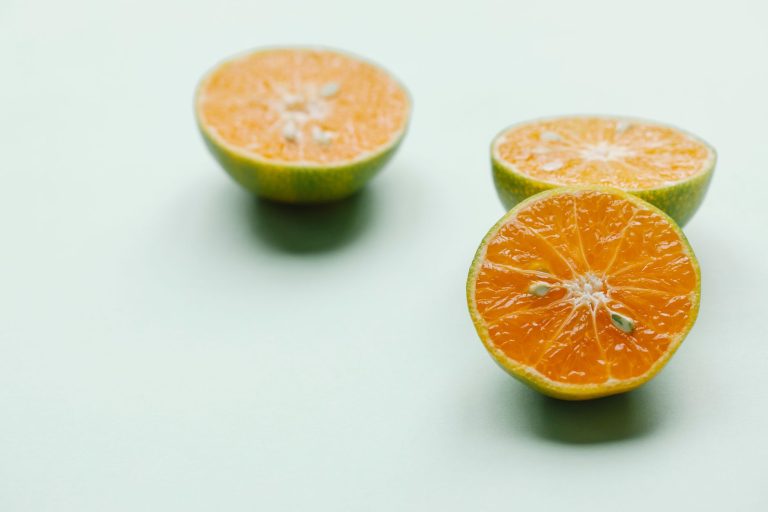 From above ripe fresh sliced oranges on light green background for healthy lifestyle concept